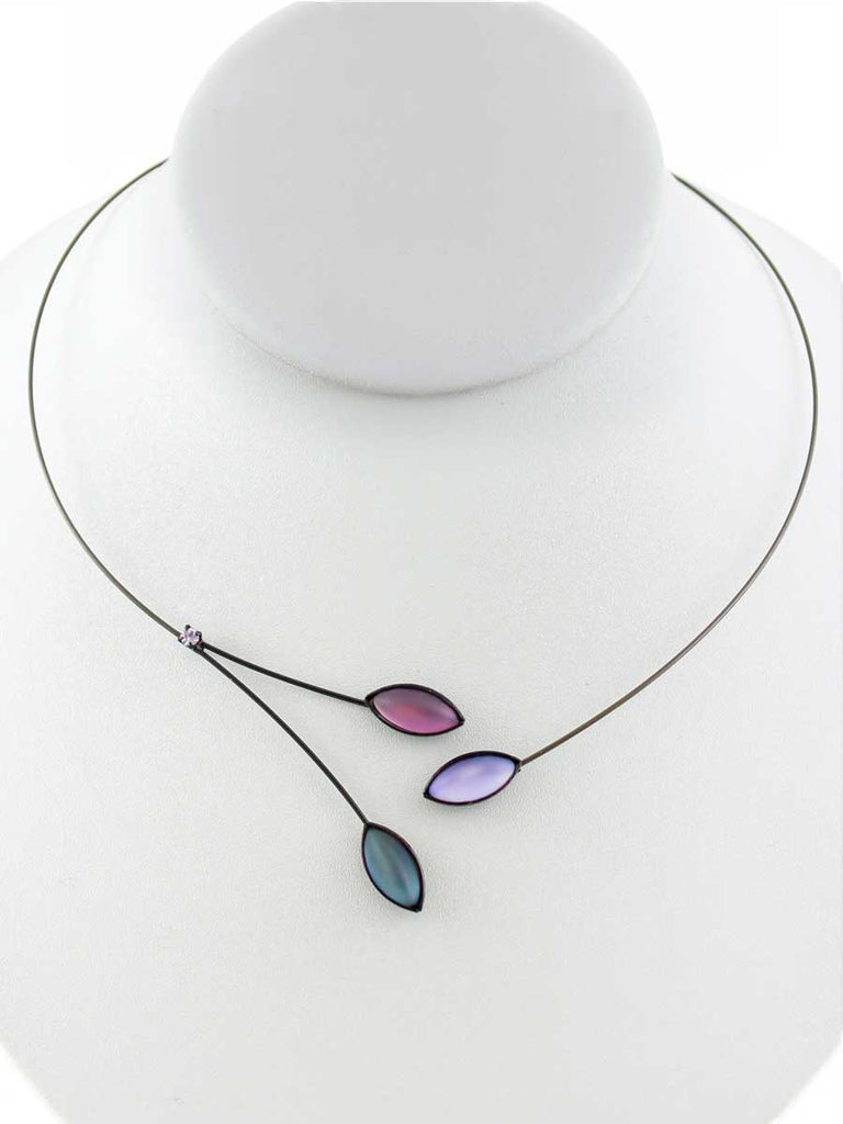 Necklace with blue and purple glass beads on a gray display