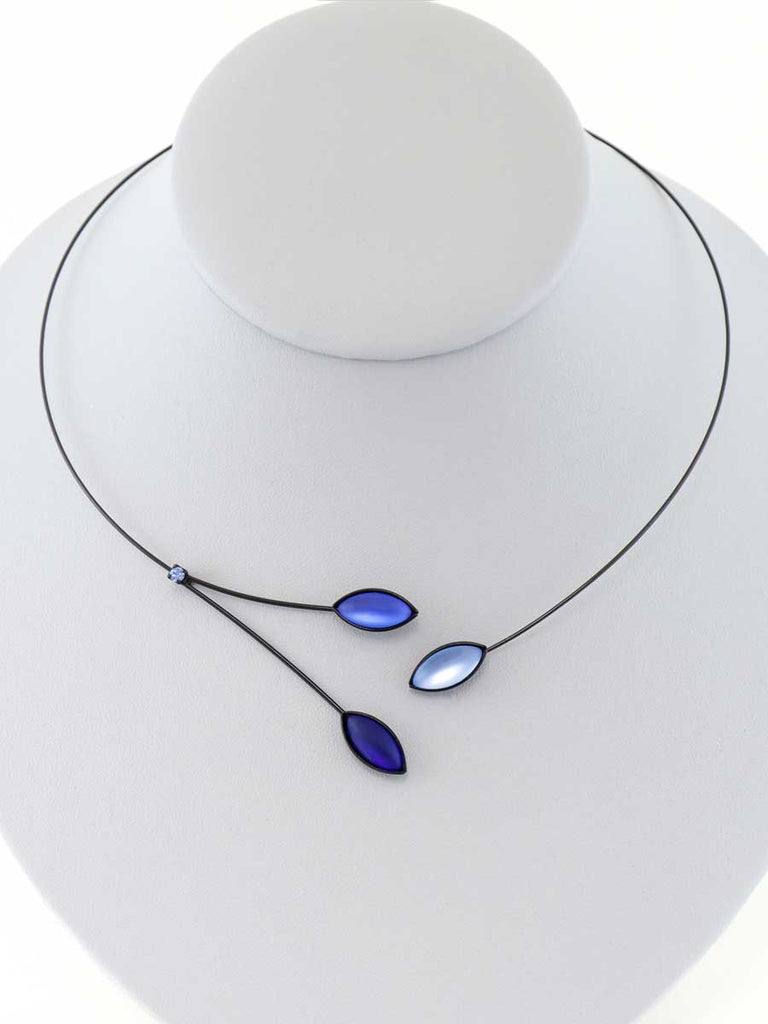 Necklace with blue glass beads on a gray display