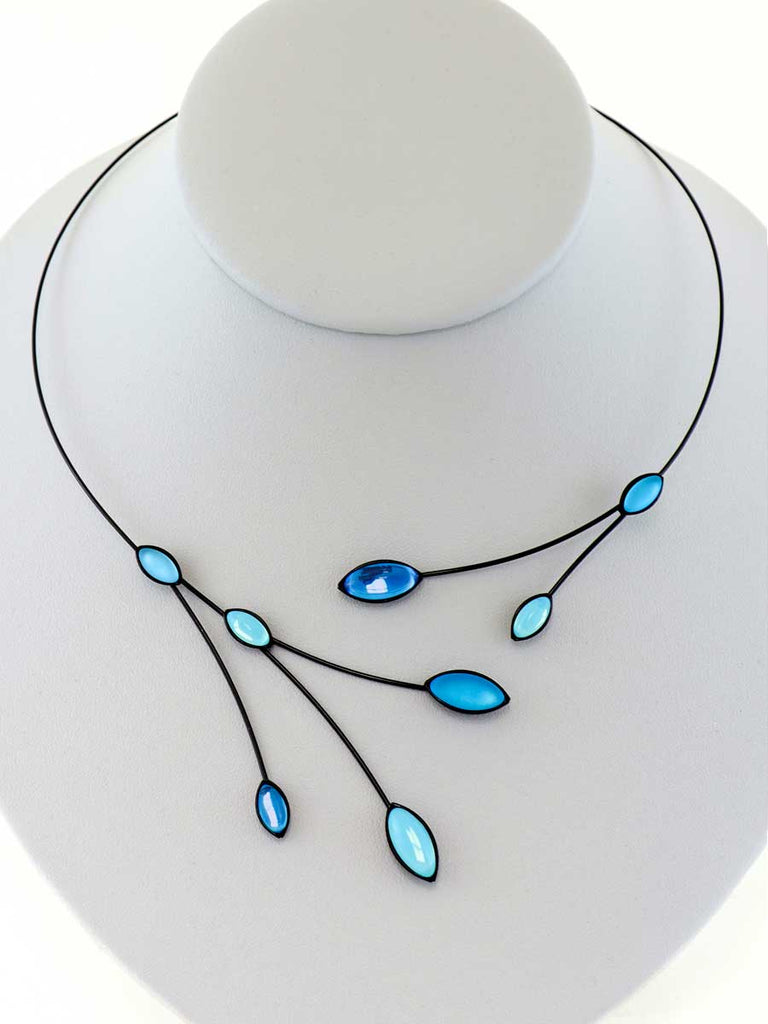 necklace with blue glass beads on a gray display