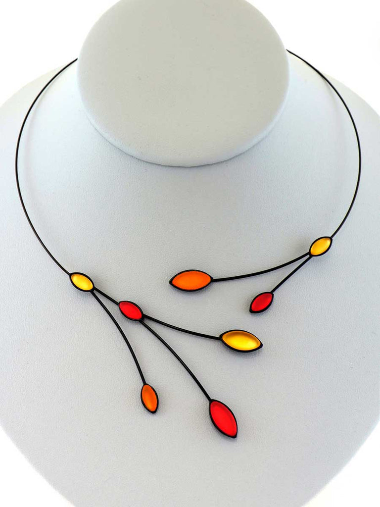necklace with red and orange glass beads on a gray display
