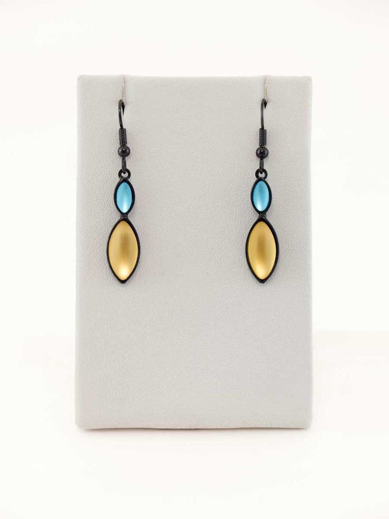 A pair of aqua and yellow glass bead earrings on a gray display