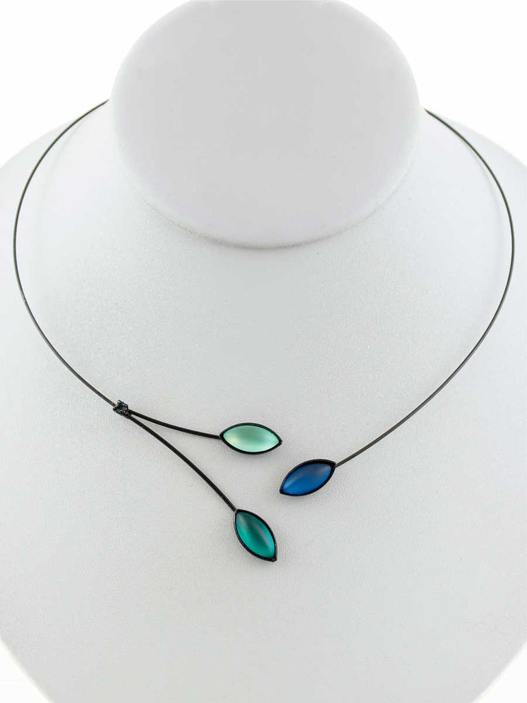Necklace with green and blue glass beads on a gray display