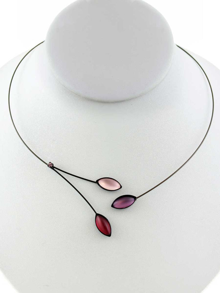 Necklace with pink, purple, and red glass beads on a gray display