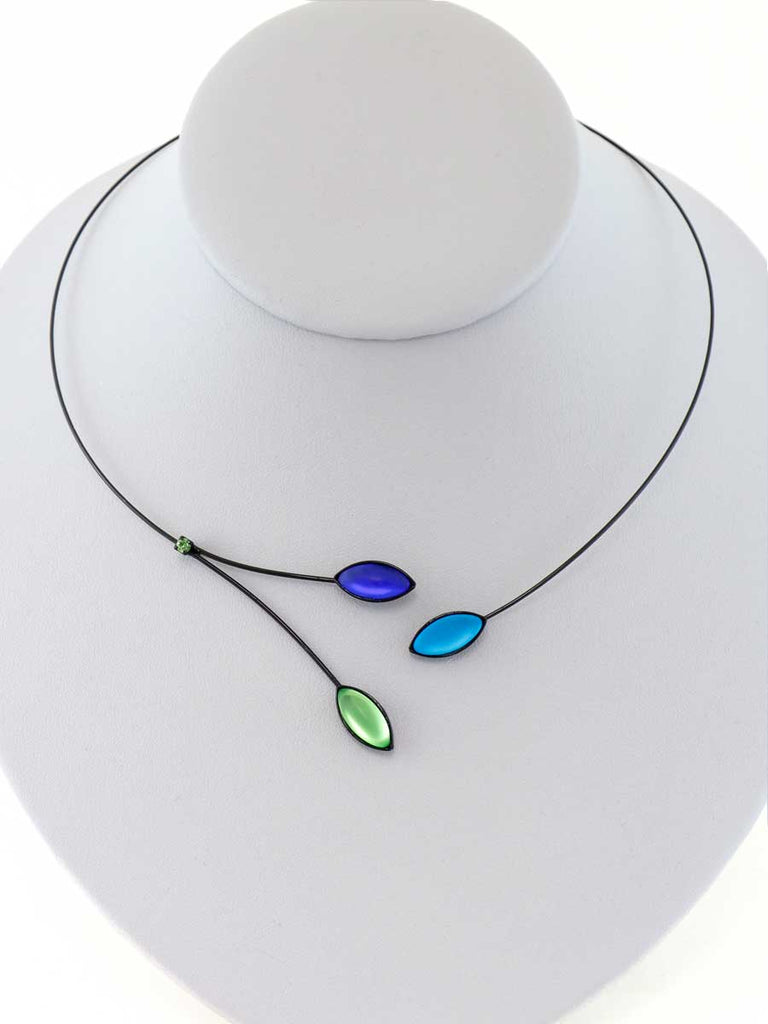 Necklace with blue and green glass beads on a gray display
