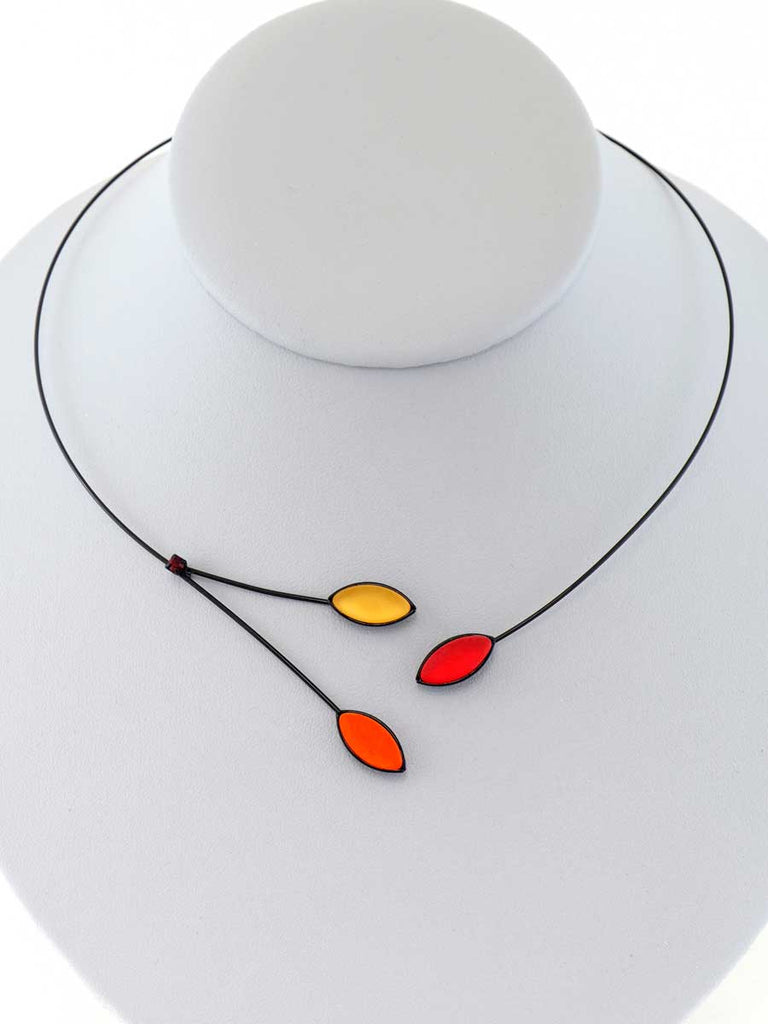 Necklace with yellow, orange, and red glass beads on a gray display