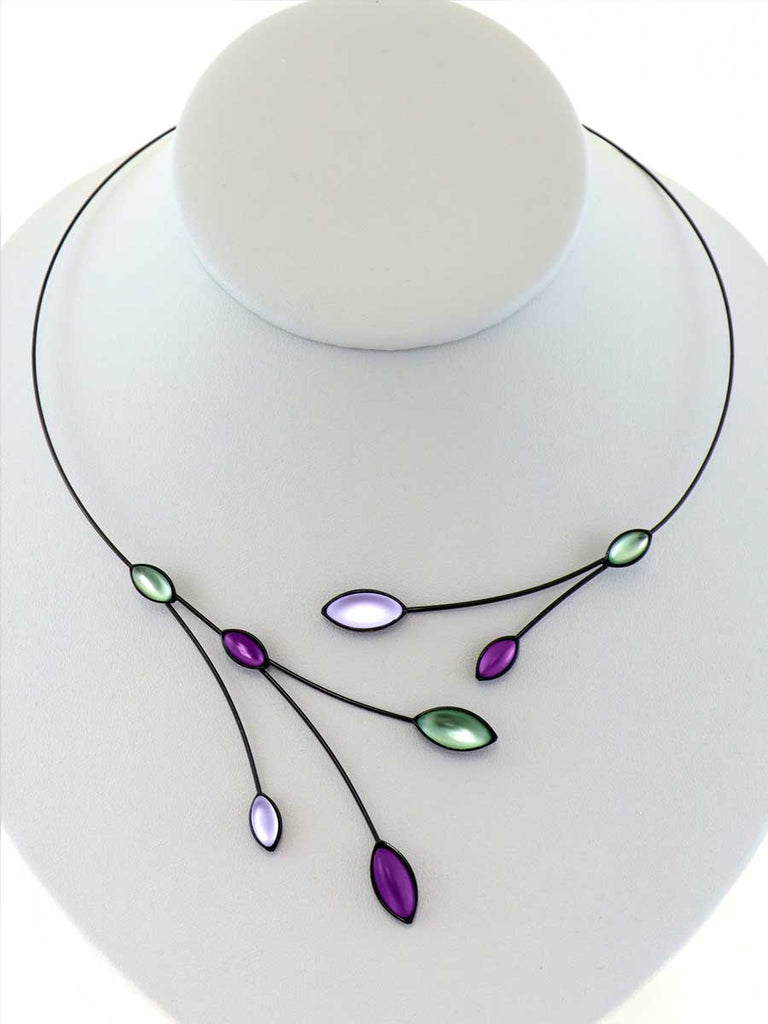 necklace with green and purple glass beads on a gray display