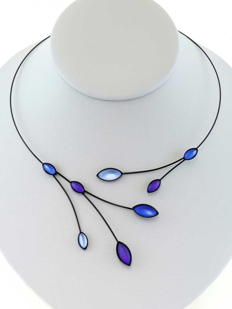 necklace with blue glass beads on a gray display