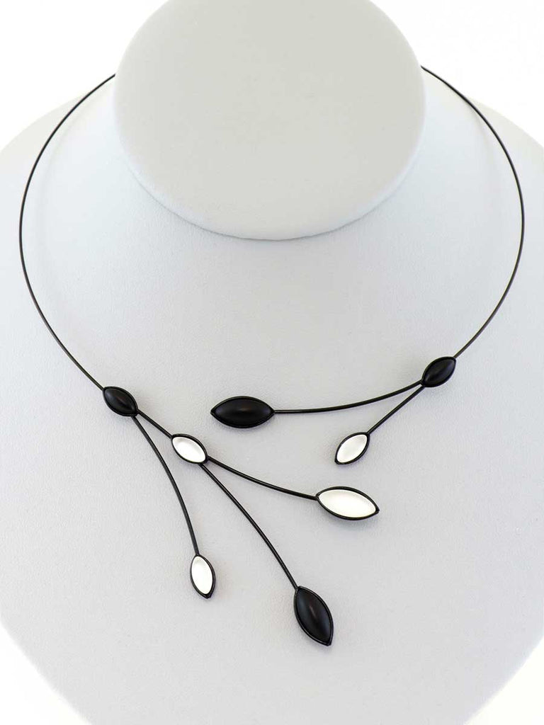 necklace with black and white glass beads on a gray display