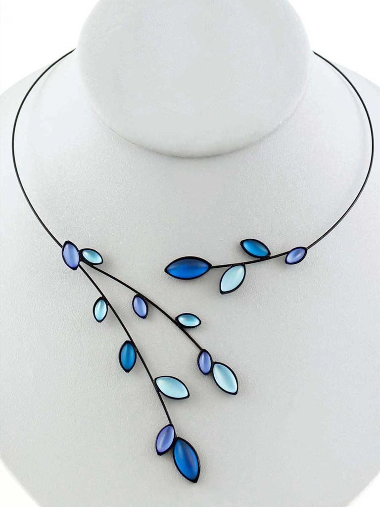 Necklace with blue glass beads on a gray display