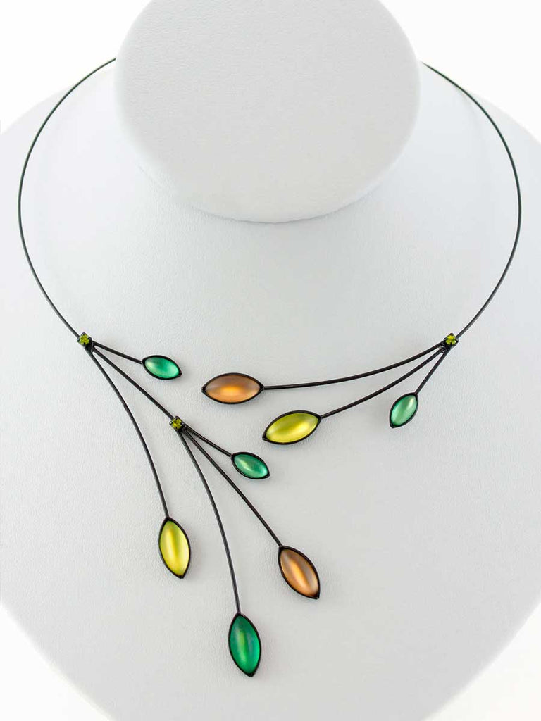Necklace with yellow, green, and brown glass beads on a gray display