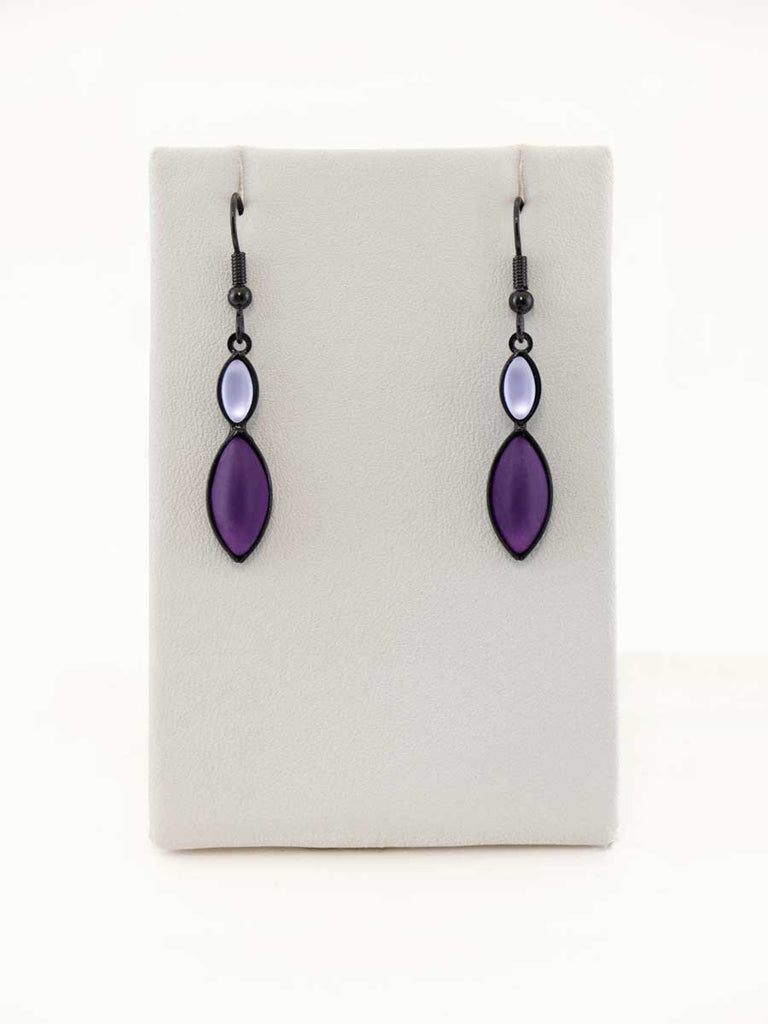 A pair of purple glass bead earrings on a gray display