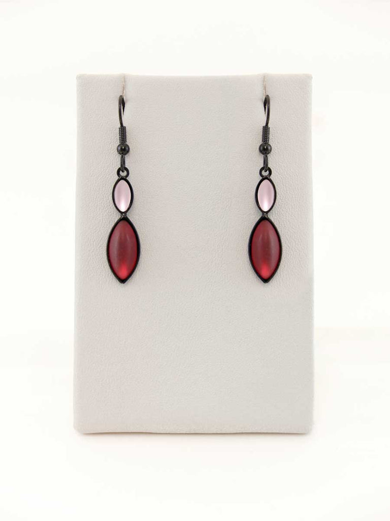 A pair of pink and red glass bead earrings on a gray display