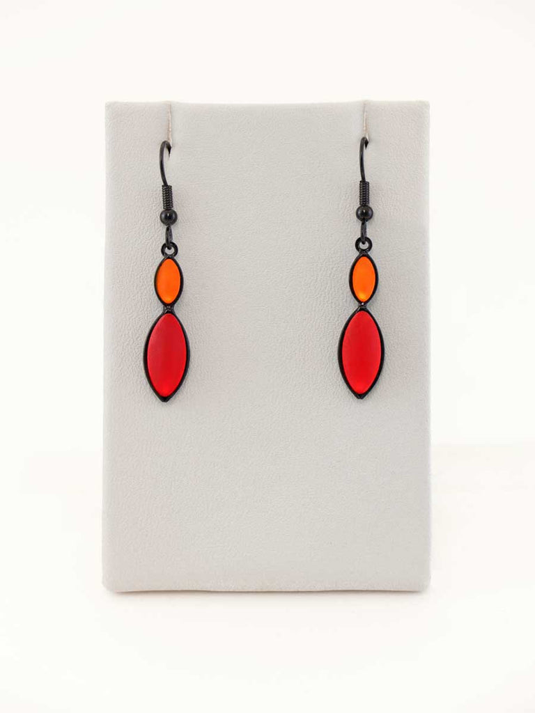 A pair of orange and red glass bead earrings on a gray display