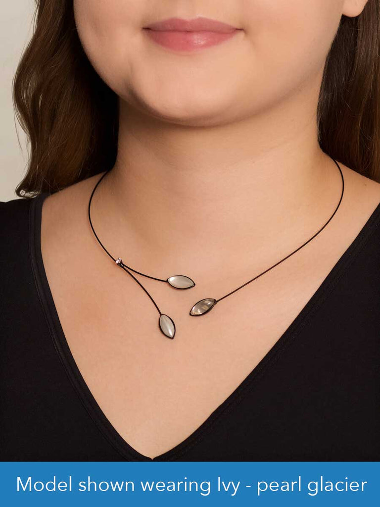 Close up of a model wearing a glass and wire necklace