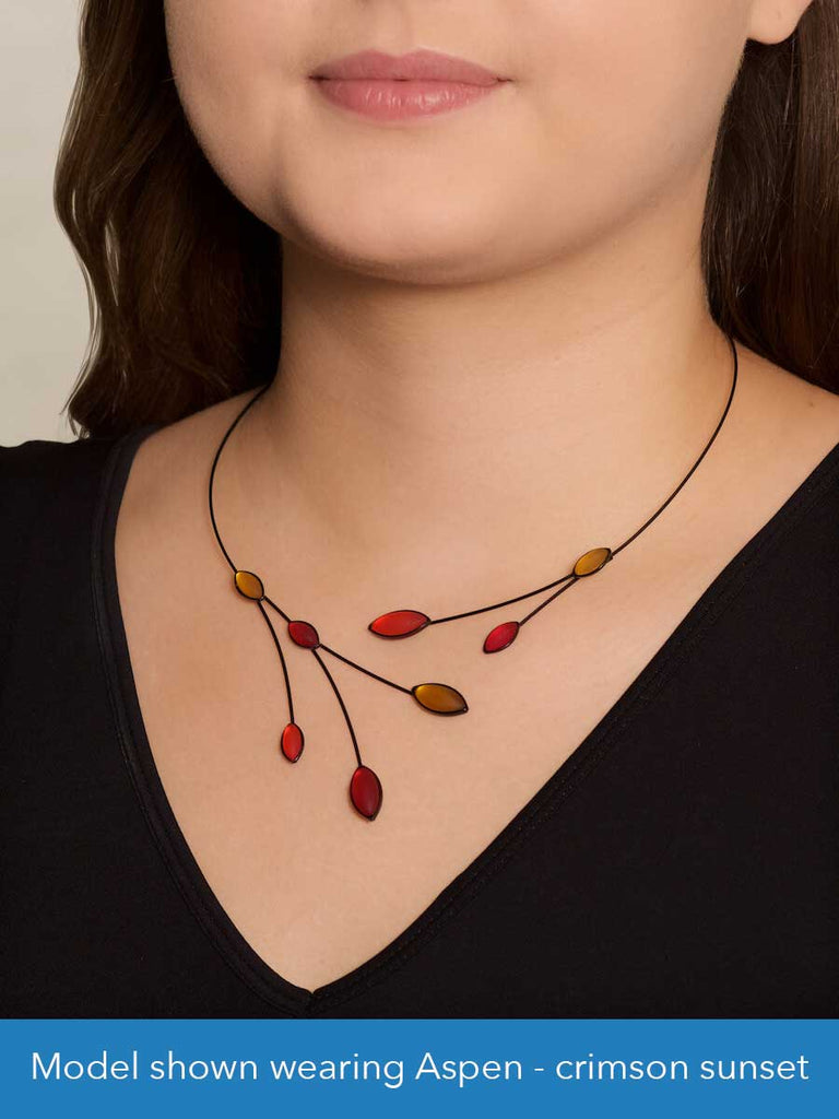 Close up of a model wearing a glass and wire necklace